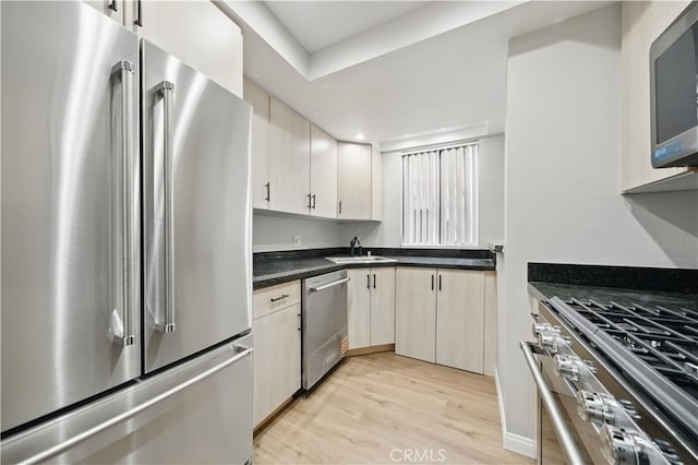 7826 Topanga Canyon Blvd Unit 218, Canoga Park, CA 91304 - kitchen with stainless steel appliances, a sink, light wood finished floors, and dark countertops