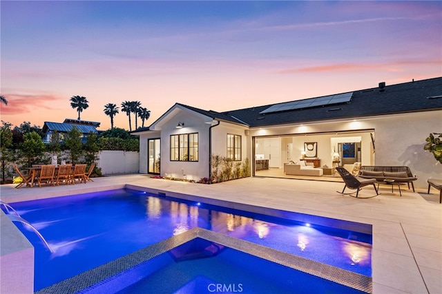 1530 Anita Ln, Newport Beach, CA 92660 - back of house at dusk featuring outdoor lounge area, a patio area, solar panels, and stucco siding