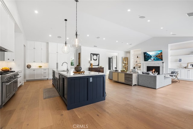 1530 Anita Ln, Newport Beach, CA 92660 - kitchen with vaulted ceiling, white cabinets, light countertops, double oven range, and a kitchen island with sink