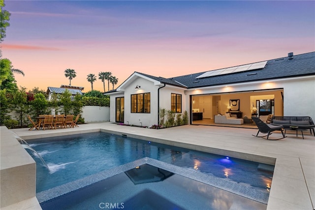 1530 Anita Ln, Newport Beach, CA 92660 - back of property at dusk with an outdoor hangout area, outdoor dining space, roof mounted solar panels, a patio, and stucco siding