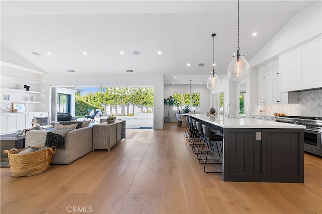1530 Anita Ln, Newport Beach, CA 92660 - kitchen with range with two ovens, white cabinets, light countertops, a large island, and a breakfast bar area