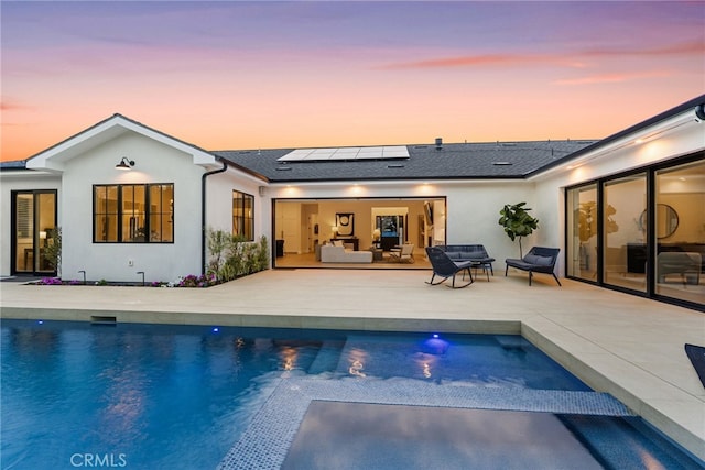 1530 Anita Ln, Newport Beach, CA 92660 - rear view of property featuring solar panels, an outdoor living space, a patio, an outdoor pool, and stucco siding