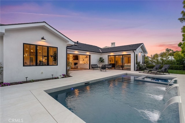 1530 Anita Ln, Newport Beach, CA 92660 - back of house at dusk featuring a patio area, stucco siding, and a pool with connected hot tub