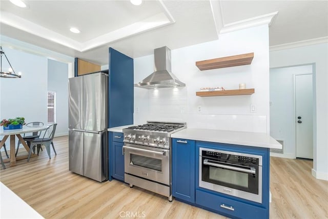 16 Allyssum, Rancho Santa Margarita, CA 92688 - kitchen with appliances with stainless steel finishes, wall chimney range hood, blue cabinets, light countertops, and light wood finished floors