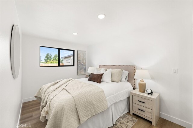 bedroom featuring baseboards, light wood-style floors, and recessed lighting