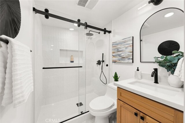 full bath featuring toilet, a shower stall, and vanity