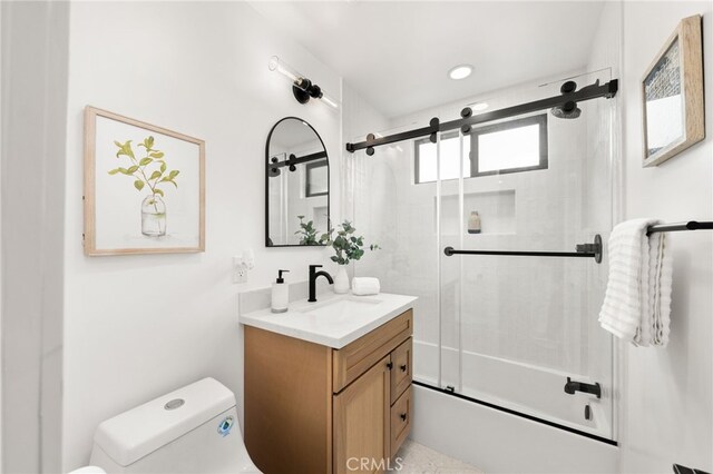 full bathroom featuring toilet, vanity, and shower / bath combination with glass door