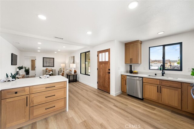 kitchen with stainless steel dishwasher, a sink, recessed lighting, light wood-style floors, and light countertops