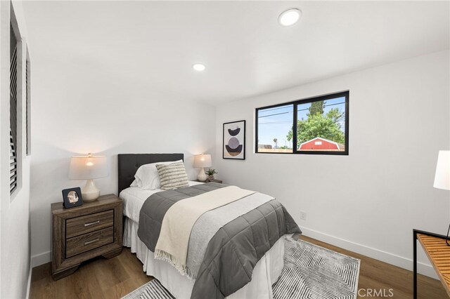bedroom featuring baseboards, wood finished floors, and recessed lighting