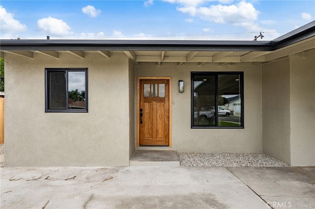 doorway to property featuring stucco siding