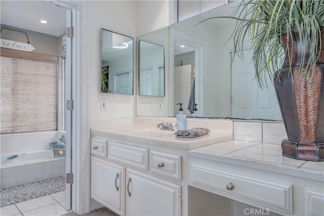 bathroom featuring tile patterned floors, a garden tub, and vanity