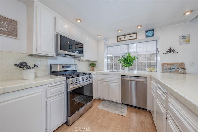kitchen featuring appliances with stainless steel finishes, white cabinets, and recessed lighting