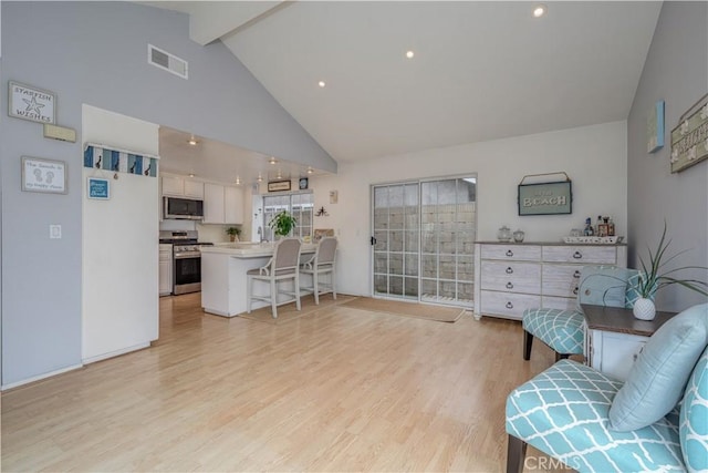 living area with light wood-style flooring, beamed ceiling, and high vaulted ceiling