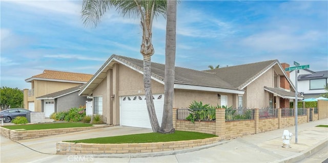 view of side of home featuring an attached garage, stucco siding, fence, and driveway
