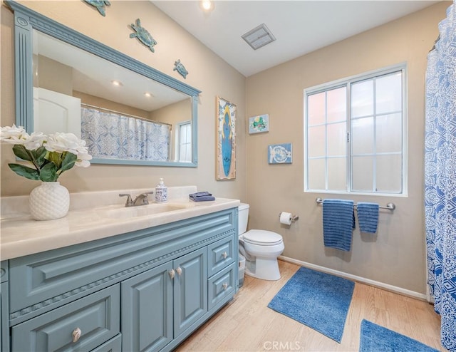 full bath featuring wood finished floors, toilet, vanity, and baseboards