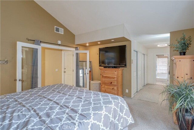 carpeted bedroom with high vaulted ceiling and french doors