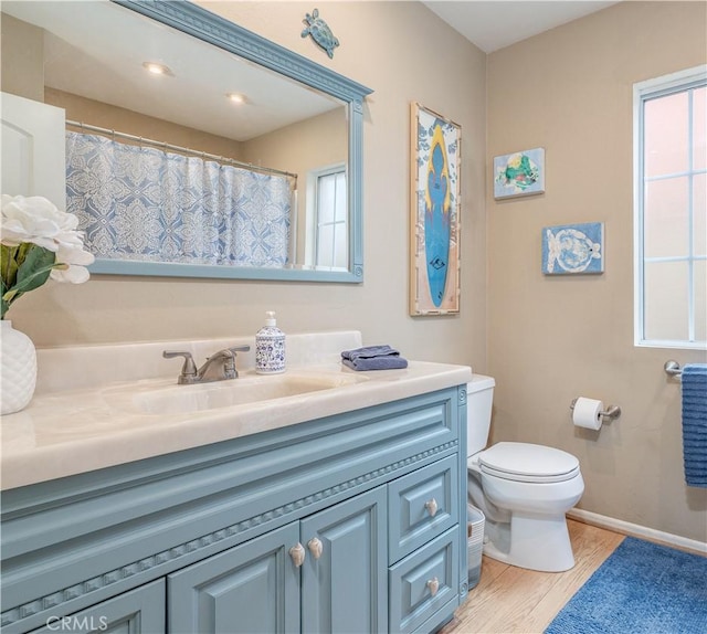 full bathroom with vanity, toilet, wood finished floors, and baseboards