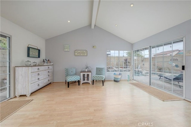 sitting room featuring beam ceiling, light wood-style floors, plenty of natural light, and high vaulted ceiling