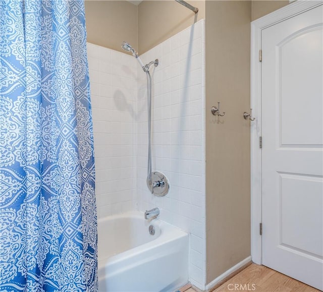 bathroom featuring shower / bathtub combination with curtain and baseboards