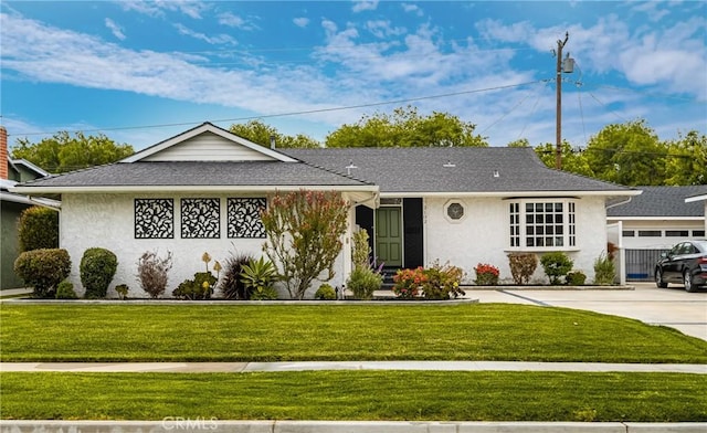 ranch-style house featuring stucco siding, a front yard, and concrete driveway