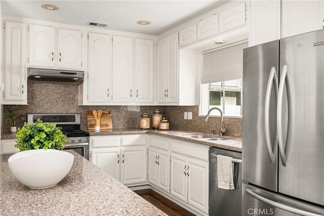 kitchen featuring appliances with stainless steel finishes, under cabinet range hood, a sink, and white cabinets