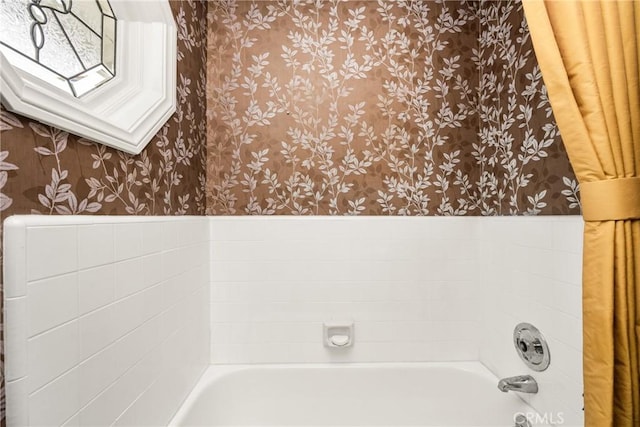 full bath with wallpapered walls, wainscoting, and a skylight