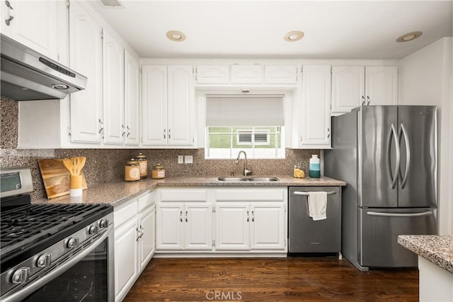 kitchen featuring appliances with stainless steel finishes, a sink, under cabinet range hood, white cabinetry, and dark wood finished floors
