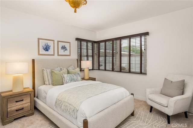 bedroom featuring light colored carpet and baseboards