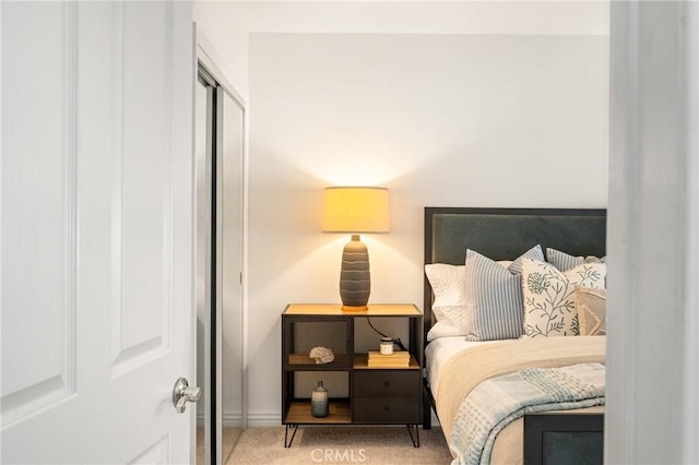 carpeted bedroom with a closet and baseboards