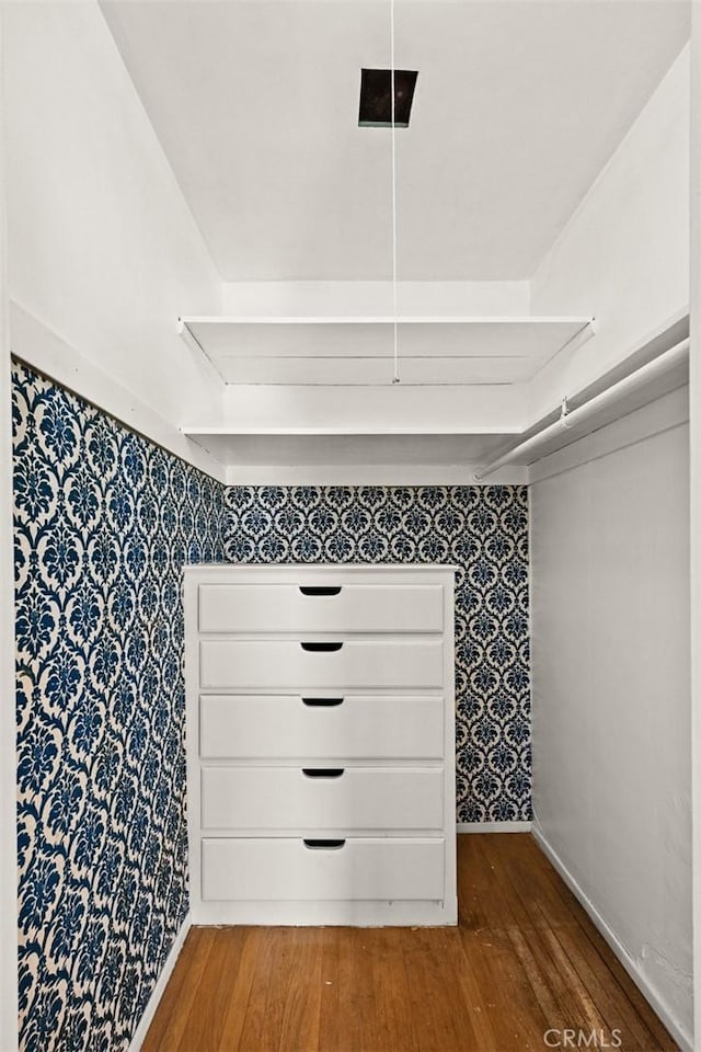 detailed view of wallpapered walls, wood finished floors, and baseboards