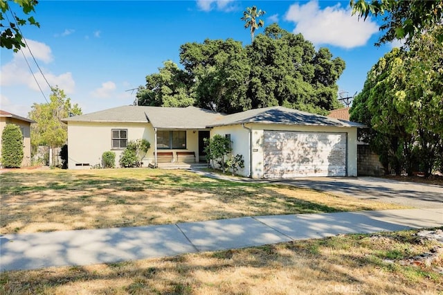 single story home with a garage, driveway, stucco siding, and a front lawn