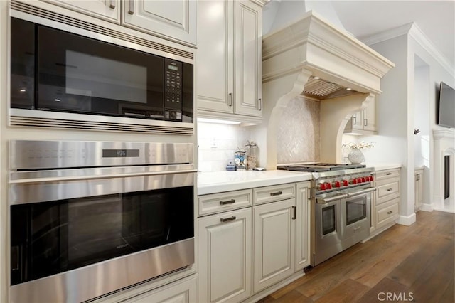 25 Tenderfoot, Irvine, CA 92602 - kitchen with appliances with stainless steel finishes, custom range hood, light countertops, crown molding, and backsplash