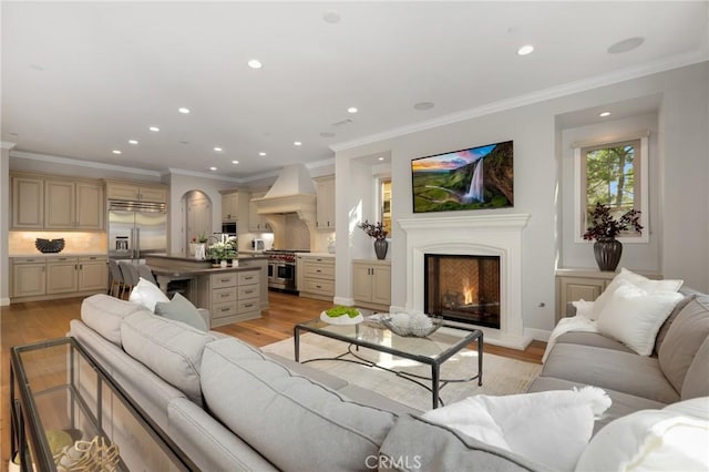 25 Tenderfoot, Irvine, CA 92602 - living room with light wood-style flooring, recessed lighting, ornamental molding, and a warm lit fireplace