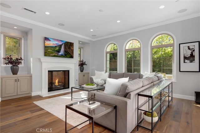 25 Tenderfoot, Irvine, CA 92602 - living room featuring wood finished floors, recessed lighting, a warm lit fireplace, baseboards, and crown molding