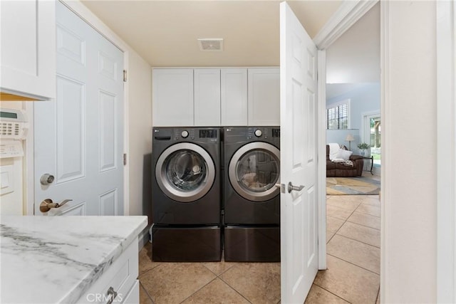 2247 Bella Ave, Upland, CA 91784 - clothes washing area with washing machine and clothes dryer, cabinet space, and light tile patterned flooring