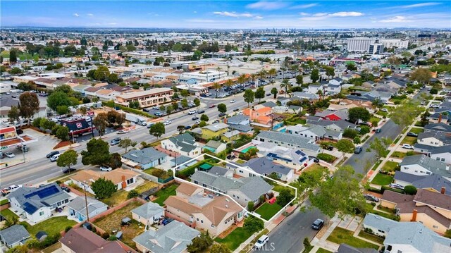 aerial view of property and surrounding area featuring property boundaries highlighted and nearby suburban area