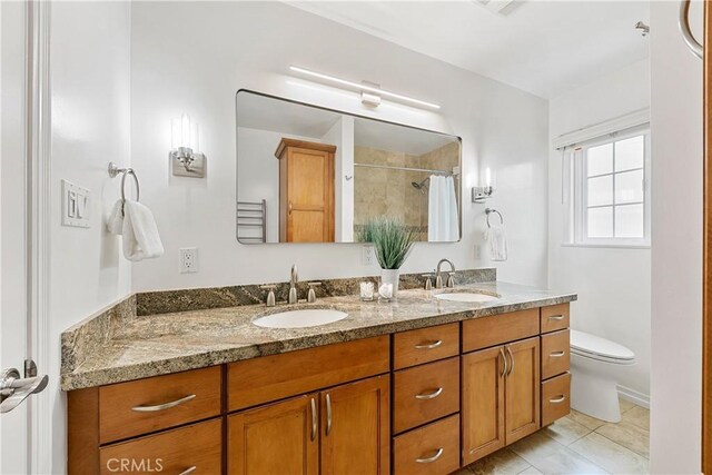 bathroom featuring double vanity, toilet, and a shower with shower curtain