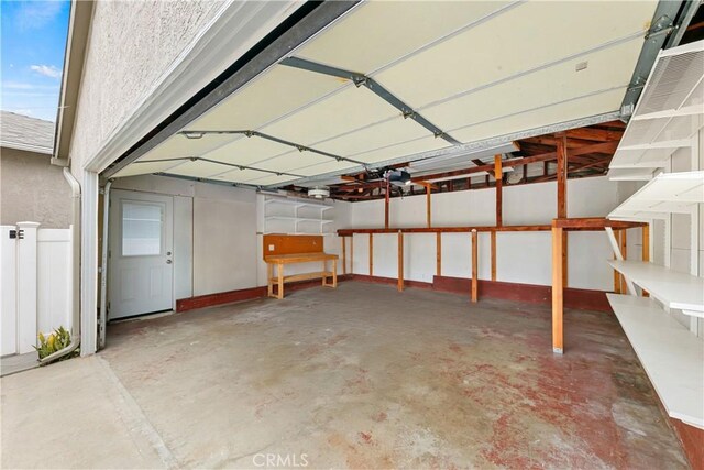 garage with fence and a garage door opener