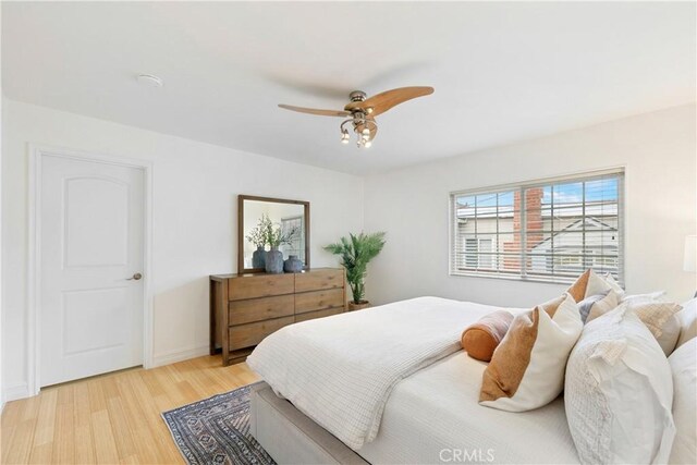 bedroom featuring light wood-style floors, ceiling fan, and baseboards
