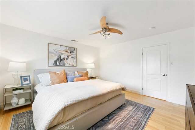 bedroom featuring light wood-type flooring, ceiling fan, and baseboards