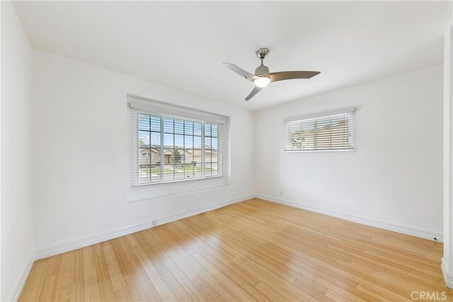 unfurnished room featuring wood finished floors, baseboards, and ceiling fan