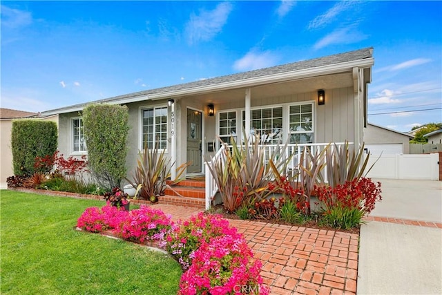 ranch-style home featuring covered porch and a front yard