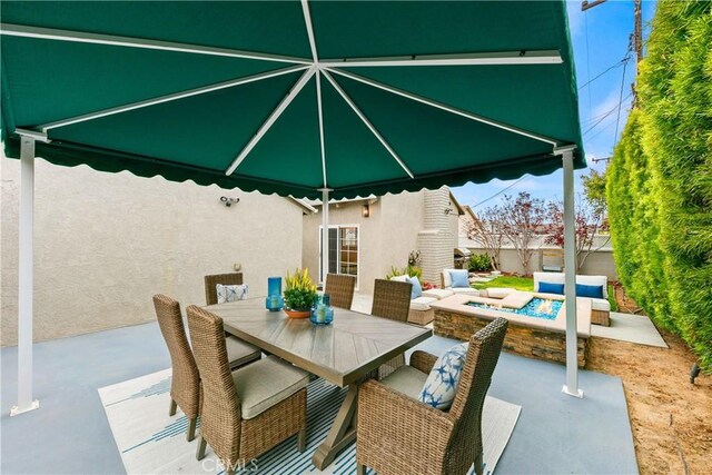 view of patio / terrace with outdoor dining area and a fire pit