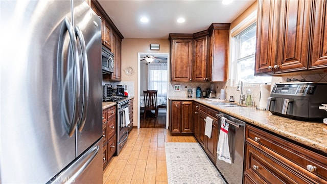 kitchen with appliances with stainless steel finishes, a sink, plenty of natural light, backsplash, and recessed lighting