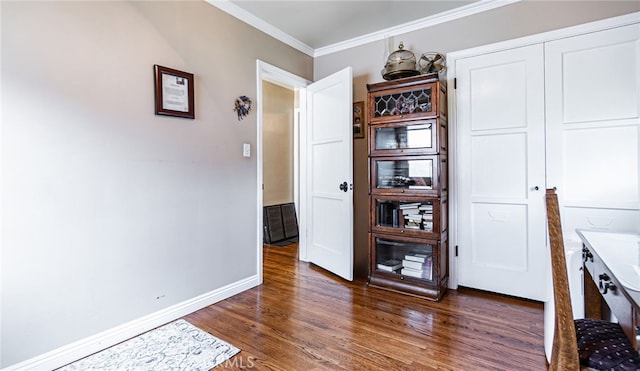 dining area with wood finished floors, crown molding, and baseboards