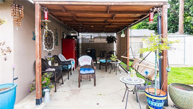 view of patio with a storage unit, an outbuilding, fence, and an outdoor hangout area