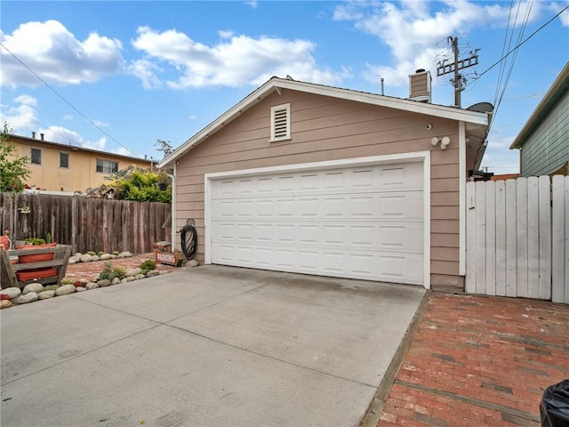 detached garage featuring fence