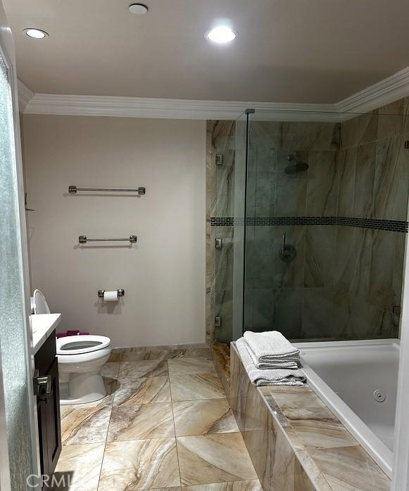 bathroom featuring crown molding, vanity, a stall shower, marble finish floors, and tiled bath