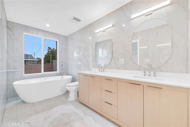 4531 N De Lay Ave, Covina, CA 91722 - bathroom with tile walls, a freestanding tub, double vanity, and marble finish floors