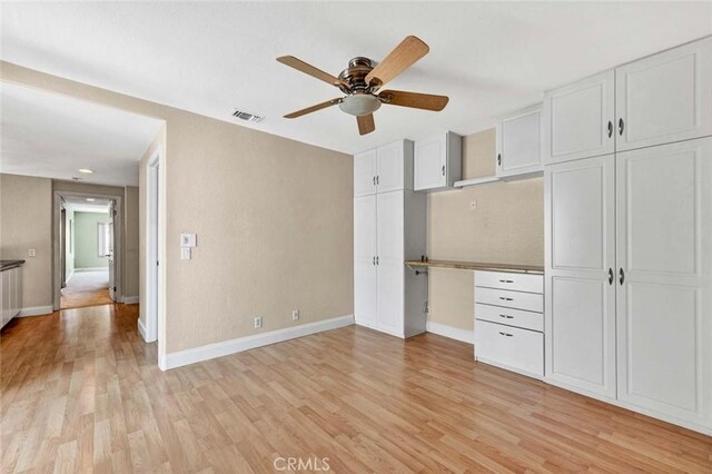 unfurnished bedroom featuring light wood finished floors, baseboards, and a ceiling fan